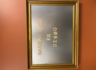 Billedramme med teksten "Dagens ord. Et besøg".