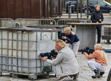 Mennesker bag tank med lasergame pistoler