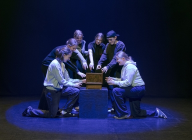 Unge står rundt om en kiste.