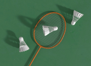 Billede af en badminton ketsjer og tre fjerbolde. Kilde: Unsplash, Allison Saeng