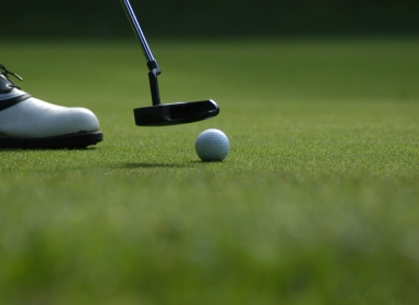 Nærbillede af golfkølle og bold.