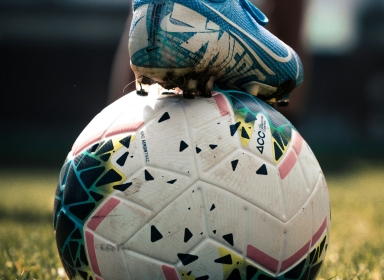 Billede af en fodbold og støvle. Kilde: Unsplash, Connor Coyne