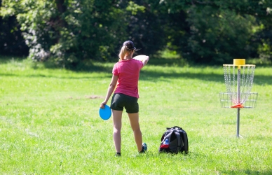 Pige, der spille discgolf på mark