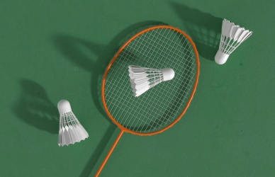 Billede af en badminton ketsjer og tre fjerbolde. Kilde: Unsplash, Allison Saeng