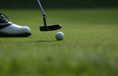 Nærbillede af golfkølle og bold.